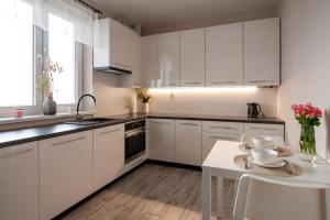 a white kitchen with white cabinets and a table at Bieślin 41 in Bieślin