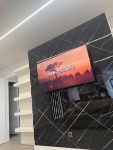 a flat screen tv on a wall in a room at Casa Noir Luxury 3BR Apartment 2 Baths Near Lisbon & Sintra in Queluz