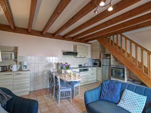 a kitchen with a blue couch and a table with chairs at Gîte Les Hortensias à Pralong - Charme et Confort pour 4 Pers avec Internet - FR-1-496-117 in Pralong +18 photos