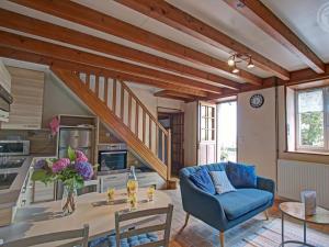 a living room with a blue couch and a table at Gîte Les Hortensias à Pralong - Charme et Confort pour 4 Pers avec Internet - FR-1-496-117 in Pralong