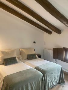 two beds sitting next to each other in a bedroom at Casa rural El Ralenco in Lécera +39 photos