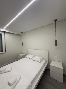a bedroom with a large white bed and two tables at Casa Noir Luxury 3BR Apartment 2 Baths Near Lisbon & Sintra in Queluz +52 photos