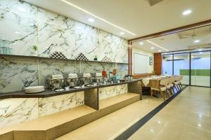a restaurant with a marble wall with a table and chairs at Treebo Landmark in Visakhapatnam
