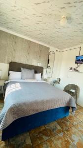 a bedroom with a large bed in a room at Mukomani Guesthouse in Soshanguve