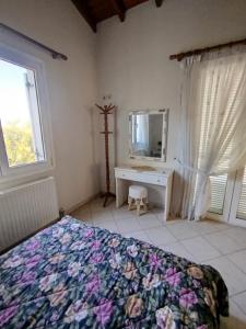 a bedroom with a bed and a desk and a mirror at DiPo's Beachside House with Sea View in Samos