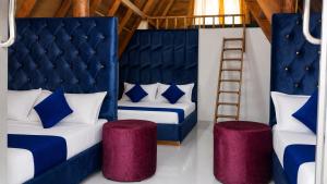 a bedroom with two beds with blue and white pillows and a ladder at Sheen Coast Beach Cabana in Nilaveli