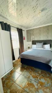 a bedroom with a large bed in a room at Mukomani Guesthouse in Soshanguve