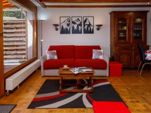 a living room with a red couch and a table at Apartment Terrasse Des Alpes 708 by Interhome in Vermala +29 photos