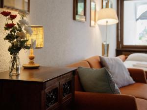 a living room with a couch and a table with a vase of flowers at Studio Terrasse Des Alpes 618 by Interhome in Crans-Montana