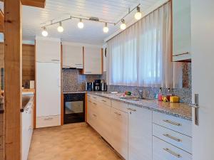 a kitchen with white cabinets and a window at Apartment Chalet Almis 5 by Interhome in Grindelwald