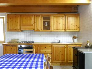 a kitchen with wooden cabinets and a stove at Holiday Home Rustico Dara Cotta by Interhome in Alpe di Scieru