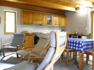 a kitchen with wooden cabinets and a table and chairs at Holiday Home Rustico Dara Cotta by Interhome in Alpe di Scieru +29 photos