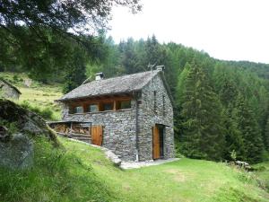 a small stone house on a hill with trees at Holiday Home Rustico Dara Cotta by Interhome in Alpe di Scieru