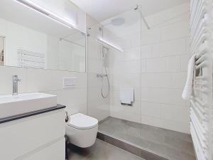 a white bathroom with a toilet and a shower at Apartment Allod Park Haus B 202 by Interhome in Davos