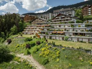 an apartment building with a garden on a hill at Apartment Terrasse Des Alpes 917 by Interhome in Crans-Montana