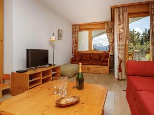 a living room with a bottle of wine and a table at Apartment Terrasse Des Alpes 917 by Interhome in Crans-Montana +34 photos