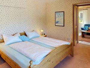 a bedroom with a wooden bed with blue pillows at Apartment Maier-1 by Interhome in Triberg