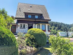 a house with a gambrel roof and bushes at Apartment Maier-1 by Interhome in Triberg