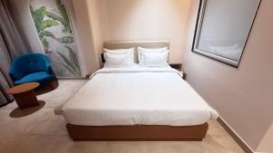 a bedroom with a bed and a blue chair at Oryana Resort in Udaipur