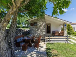 a patio with a table and chairs under a tree at Holiday Home Tomazin by Interhome in Pazin