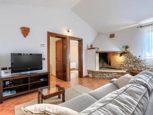 a living room with a couch and a tv at Holiday Home Tomazin by Interhome in Pazin