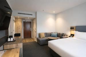 a hotel room with a bed and a couch at Holiday Inn London Luton North in Luton