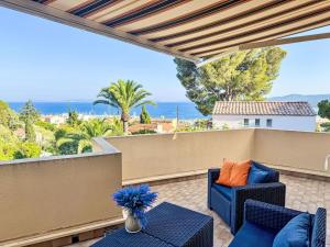 a patio with chairs and tables and a view of the ocean at Apartment Cadet Rousse-6 by Interhome in Le Lavandou