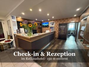 a lobby with a counter with a vase of flowers at Hotel Miriquidi All Inklusive in Kurort Oberwiesenthal
