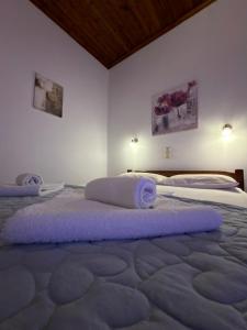 two beds in a room with purple towels on them at Litus Amoris in Sidari +35 photos