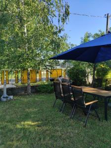 a wooden table and chairs with an umbrella at Apartman Garami Porta in Mezőkövesd