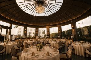 a banquet hall with tables and chairs and a chandelier at White Wharf Manesar in Gurgaon