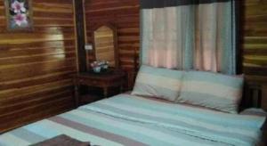 a bedroom with a bed with a pillow and a table at Baanraimaetha Resort in Bān Phea +4 photos