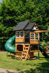 a small wooden play house with a slide at Luxus Suite mit Whirlpool im Hotel Rupertihof in Ainring