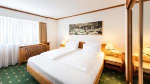 a hotel room with a large bed and a window at Sonnenhof Resort Himmelreich Bayerischer Wald in Lam