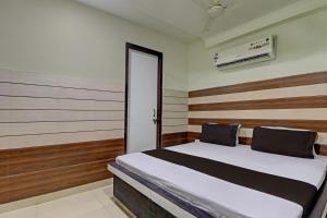 a bedroom with a bed with wooden walls and a door at Collection O The Legend Hotel, Hisar in Hisār