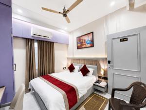 a hotel room with a bed and a chair at NEAR SHREE RAM JANM BHOOMI - HOTEL SHREE RR - Wi-Fi - Parking- Luxury Rooms - Best Family Hotel In Ayodhya in Ayodhya +7 photos