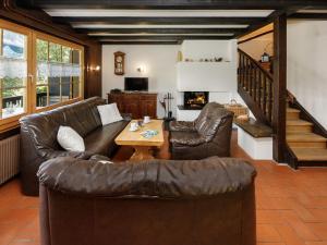a living room with leather furniture and a table at Apartment Chalet L'Aube by Interhome in Vers L'Eglise