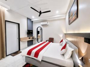 a bedroom with a bed with a red and white striped blanket at NEAR SHREE RAM JANM BHOOMI - HOTEL SHREE RR - Wi-Fi - Parking- Luxury Rooms - Best Family Hotel In Ayodhya in Ayodhya