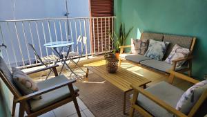 a living room with a couch and chairs on a balcony at L'Arymarius 12 in Saint-Pierre