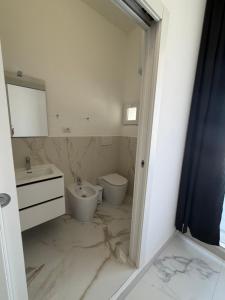 a white bathroom with a sink and a toilet at Alexandra Rooms & Suitess in Sassari +7 photos