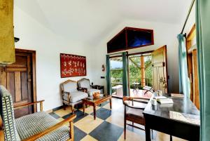 a living room with a table and chairs at Indo Asia Heritage Coorg, formerly Heritage Resort Coorg in Madikeri