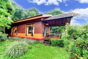 a small house with a ladder in a yard at Indo Asia Heritage Coorg, formerly Heritage Resort Coorg in Madikeri
