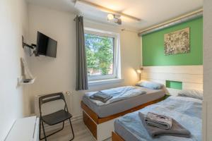 a room with two beds and a tv and a chair at Flensbed Hotel & Hostel in Flensburg +84 photos