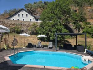 a swimming pool with chairs and a house in the background at le rivalet in Montaigut-le-Blanc +11 photos
