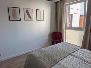 a bedroom with a bed and a window and a chair at Apartament Klonova na Mazurach in Olecko