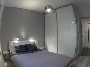 een slaapkamer met een wit bed en een lamp bij Apartament z Ogrodem in Polanica-Zdrój