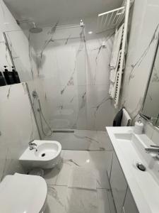 a white bathroom with a toilet and a sink at 16 zeros villa in Paralia Katerinis