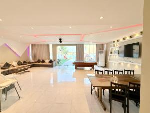 a large living room with a television and a couch at فيلا السعادة بشاطي خاص درة العروس in Durat Alarous