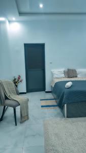 a bedroom with a bed and a chair and a table at Villa Madiba in Somone