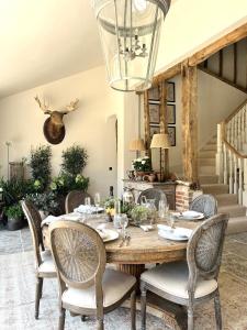 a dining room with a wooden table and chairs at Surrey Barn, Newly Renovated in Ripley